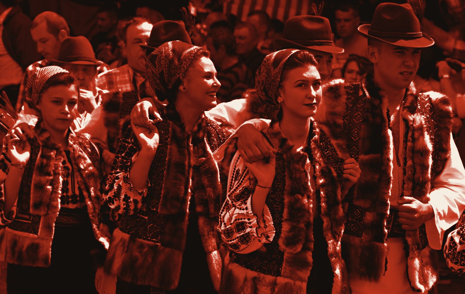 Tineri în costume populare românești dansând, tratat monocrom în roșu